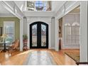 Grand foyer with hardwood floors, arched doorways, and an ornate wrought iron front door at 2088 Skybrooke Ct, Hoschton, GA 30548