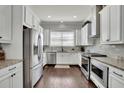 Bright kitchen features stainless steel appliances, white cabinetry, granite countertops, and a window for natural light at 318 Lantana Ln, Woodstock, GA 30188