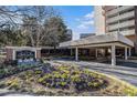 The City Heights Condominiums entrance with colorful flowerbeds and covered drop-off area at 375 Ralph Mcgill Ne Blvd # 804, Atlanta, GA 30312