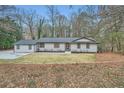 Inviting front exterior shot showcasing a charming home, grassy lawn, and nicely trimmed greenery at 1555 Sunnybrook Farm Rd, Atlanta, GA 30350