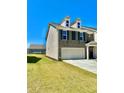 Well-manicured lawn compliments this townhome featuring a three car garage, and stone and siding exterior at 2560 Quarterdeck Dr, Cumming, GA 30041
