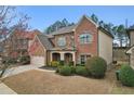 Two-story home with brick and vinyl siding, lush landscaping, and a convenient two-car garage at 2126 Roberts View Trl, Buford, GA 30519