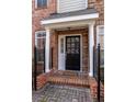 Inviting front entrance with brick walkway, columns, and a black front door with glass panes and sidelights at 1175 Glenridge Pl, Atlanta, GA 30342