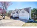 View of two-story home showcasing a two-car garage and landscaping at 6219 Wurtenburg Ct, Stone Mountain, GA 30087