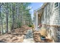 The exterior view showcases a pathway alongside the house leading to a wooded area at 233 Hiawassee Dr, Woodstock, GA 30188