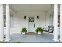 Cozy front porch featuring white columns, pendant lighting, plants, and a charming swing for relaxation at 6 Arc Ne Way, Atlanta, GA 30305