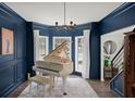 Elegant living room with a grand piano, bay window, and sophisticated decor at 7880 Brands Hatch Blvd, Cumming, GA 30040