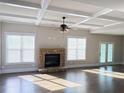 Open concept living room with stone fireplace, coffered ceilings, and French doors at 3988 Two Bridge Drive, Buford, GA 30519