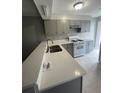 Updated kitchen with modern white countertops, gray cabinets, and stainless faucet at 465 Prince Of Wales, Stone Mountain, GA 30083