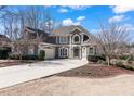 Stately two-story home with a long driveway, manicured landscaping, and a three-car garage at 160 Antler Trl, Alpharetta, GA 30005