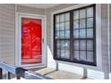 Balcony with grey railings and a red front door with a matching red screen door at 586 Windchase Ln, Stone Mountain, GA 30083