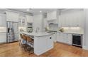 Bright kitchen boasts stainless appliances, center island with seating, and sleek white cabinets at 3330 Camellia Ln, Suwanee, GA 30024
