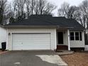 Inviting single-level home showcasing an attached garage, neutral siding, and a classic roof design on a cloudy day at 3231 Liberty Commons Nw Dr, Kennesaw, GA 30144