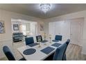 Spacious dining room with modern chandelier, table, and a view into the living room at 3677 Rosebud Park Dr, Snellville, GA 30039