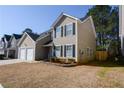 View of a two-story home featuring a two-car garage and landscaping at 3677 Rosebud Park Dr, Snellville, GA 30039