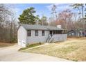 Charming single-story home with gray siding, black trim, a front porch, and an attached two-car garage at 2995 Clearwater Dr, Douglasville, GA 30135