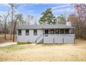 Charming single-story home with gray siding, black trim, and a welcoming front porch, perfect for relaxing outdoors at 2995 Clearwater Dr, Douglasville, GA 30135