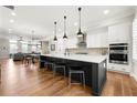 Open kitchen features a large island with seating, pendant lighting, and modern appliances at 714 Opera Ln, Alpharetta, GA 30009