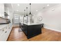 Modern kitchen features a large island, white cabinets, granite countertops, and stainless steel appliances at 714 Opera Ln, Alpharetta, GA 30009
