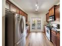Galley kitchen with stainless steel appliances, dark cabinets and stone countertops, brightened by glass patio doors at 1096 Liberty Nw Pkwy, Atlanta, GA 30318