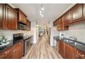 Modern kitchen with stainless steel appliances and dark cabinetry flowing into dining and living spaces at 1096 Liberty Nw Pkwy, Atlanta, GA 30318
