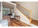Inviting foyer with hardwood floors, a staircase, and views of a sunlit living area at 1132 Venetian Ln, Hampton, GA 30228