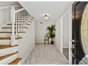 Welcoming foyer featuring a staircase with wood treads and modern tile flooring at 3087 Meadow Lark Ln, East Point, GA 30344