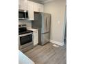 Contemporary kitchen showcases stainless steel appliances and sleek white cabinets for storage at 316 Henry Aaron Ave, Atlanta, GA 30310