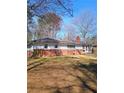 View of the backyard featuring a brick and white home with an enclosed porch area at 3800 Whitaker Ln, Lithia Springs, GA 30122