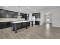 Modern kitchen featuring dark cabinetry, a large island, and stainless steel appliances, perfect for entertaining at 814 Spruce Ave, Canton, GA 30114