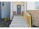 Inviting entrance with stone accents, features concrete stairs, and a wood railing leading to a front door at 481 Hammons Way, Atlanta, GA 30315