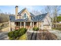 Two-story home boasts stone accents, a cozy front porch and mature landscaping at 351 Allendale Dr, Canton, GA 30115