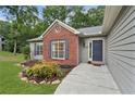 A front entrance of a single-Gathering home features brick accents and a well-maintained lawn at 4125 Gables Pl, Buford, GA 30519