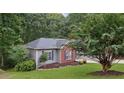 A single-Gathering home with a brick and vinyl exterior is surrounded by trees and a well-manicured lawn at 4125 Gables Pl, Buford, GA 30519