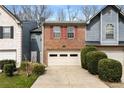 Brick townhome featuring a two-car garage, red shutters, and neatly trimmed landscaping for a welcoming curb appeal at 917 Edgewater Cir, Marietta, GA 30062