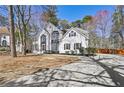 Charming two-story home with a manicured lawn and a long concrete driveway on a sunny day at 1303 Angel Falls Sw Ln, Atlanta, GA 30311