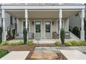 Inviting front porch with stylish seating, framed by elegant columns and lush landscaping, perfect for relaxing outdoors at 375 Banbury Xing, Alpharetta, GA 30009