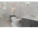 Elegant bathroom featuring a freestanding tub, gray vanity, marble countertop, and a glass enclosed shower at 7285 Cordery Rd, Cumming, GA 30040