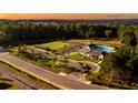 Aerial view of a community with clubhouse, pool, parking, walking trails and surrounded by lush green trees at 41 Okeechobee Way, Braselton, GA 30548