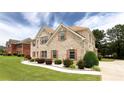 Beautiful brick home with manicured front yard and walkway lined with white rocks at 1236 Saxony Se Dr, Conyers, GA 30013