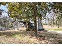 Gray two-story house showing the yard and a wooden porch nestled next to a large tree at 441 Pomona Sw Cir, Atlanta, GA 30315