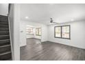 Open-concept living room with gray floors, ceiling fan, and view of kitchen through an opening at 441 Pomona Sw Cir, Atlanta, GA 30315