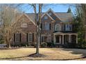 Elegant brick home featuring a classic design with a well-maintained yard and mature trees at 1615 Chattahoochee Run, Suwanee, GA 30024