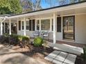 Inviting front porch with seating area and manicured landscaping, leading to a stylish entrance door with decorative details at 2723 Esquire Way, Tucker, GA 30084