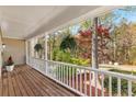 Inviting covered porch with wood flooring, white railing and hanging plants at 8078 Longleaf Dr, Villa Rica, GA 30180