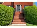 Close-up of the red brick steps and front door of a charming home, surrounded by lush greenery at 1710 Brandon Lee Sw Way, Marietta, GA 30008