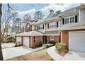 Attractive townhome showcasing a brick facade, attached garages, manicured landscaping, and convenient parking at 44 Hall Mnr, Alpharetta, GA 30022