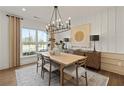 Elegant dining room featuring a modern chandelier, neutral decor, and ample natural light at 5310 Julep Ct, Cumming, GA 30028