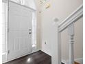 Bright entryway featuring a white door, sidelight window, and dark laminate flooring at 6595 Lancelot Ct, Riverdale, GA 30296
