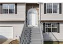 Inviting front entrance with gray stairs, a decorative stone archway, and a bright white door at 6595 Lancelot Ct, Riverdale, GA 30296